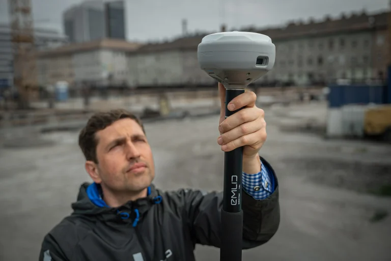 Technicien en géomatique utilisant le récepteur GNSS Reach RS4 Pro pour un relevé topographique de précision sur chantier