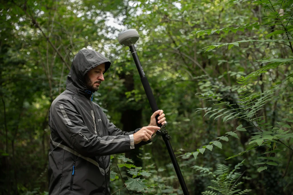 Utilisation du Reach RS4 en compensation d'inclinaison par un technicien sous la pluie